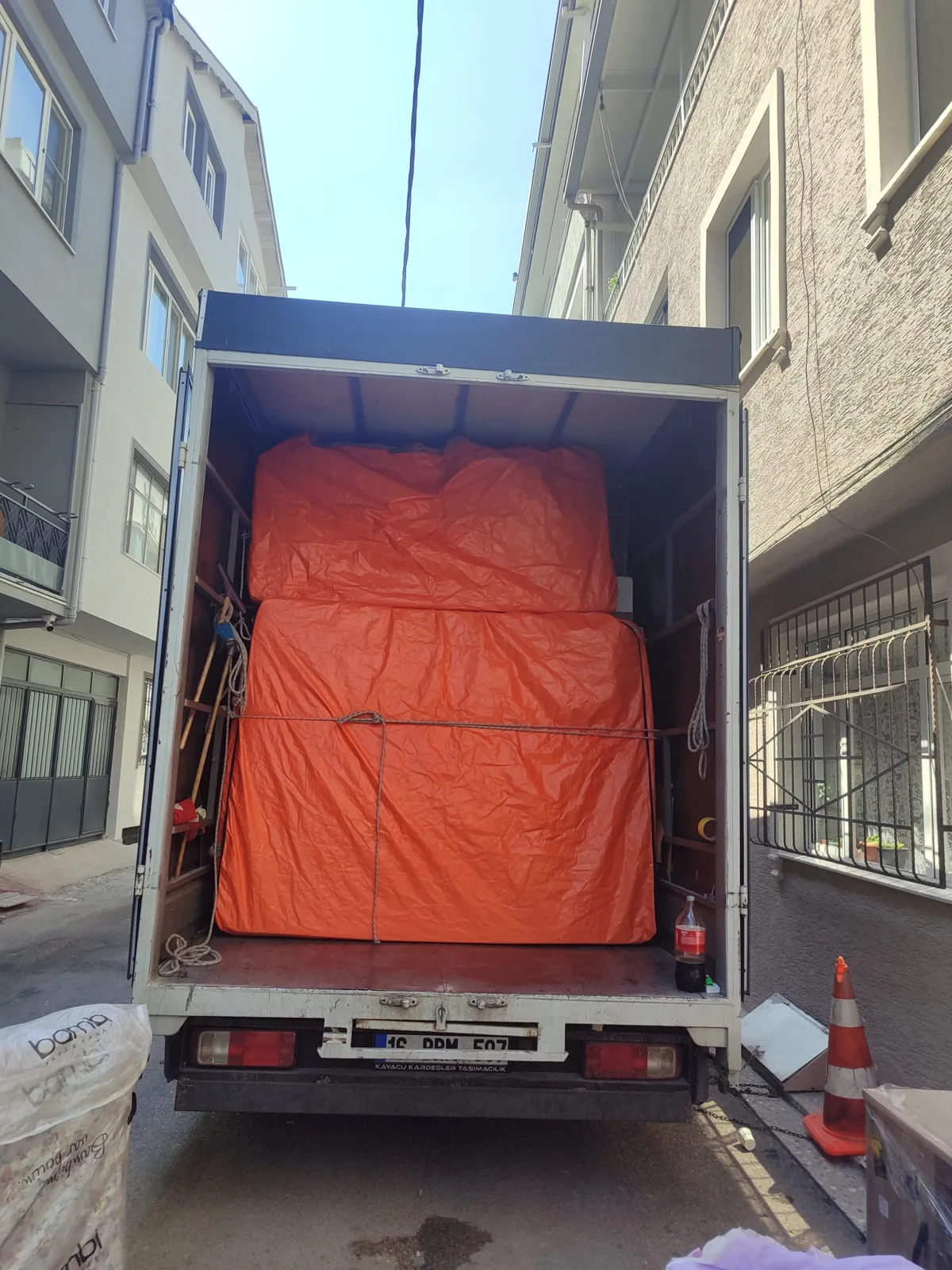 Turuncu paketli eşyaları yüklenmiş Kayacu Kardeşler nakliyat kamyonu
