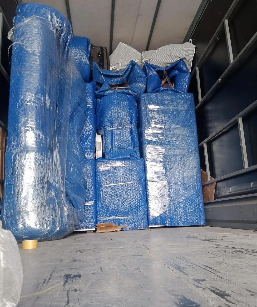 Mavi paketli mobilyaların kamyona düzenli yerleştirilmesi