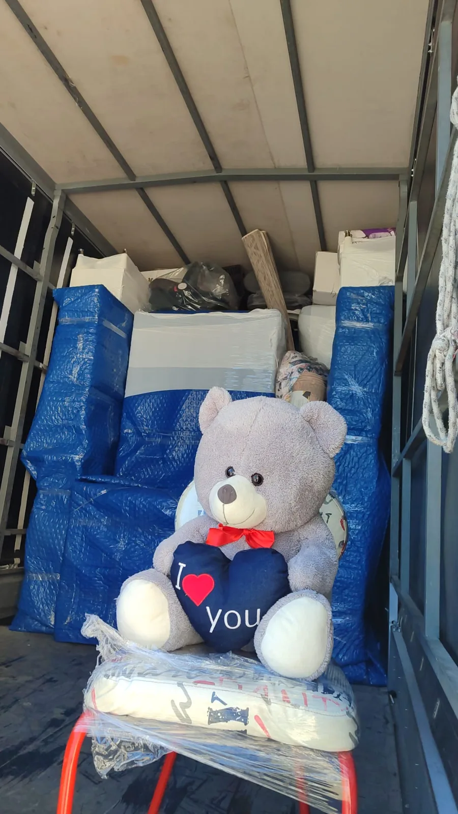 Paketli eşyaların arasında oyuncak ayıyla nakliyat kamyonu