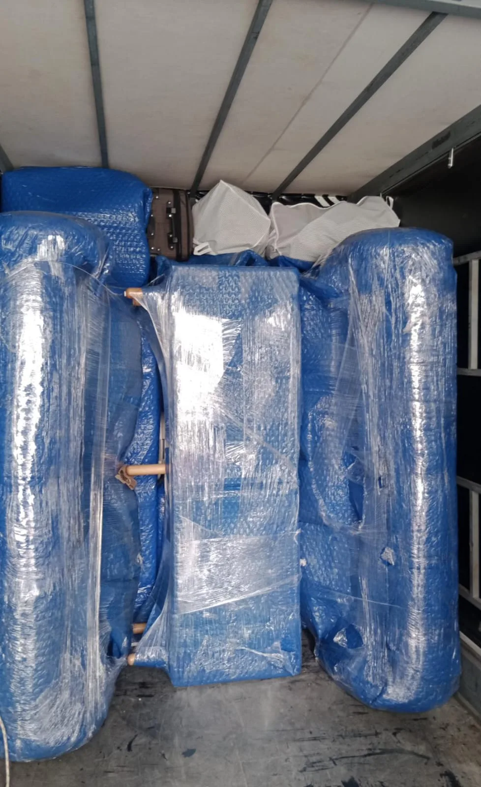Mavi naylonla paketlenmiş koltuk takımı nakliyat kamyonunda